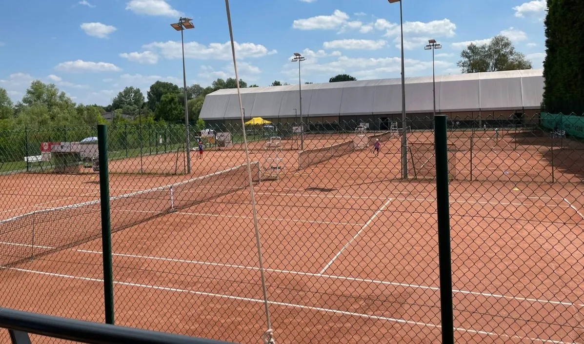 Les courts en terre battue du club, avec la halle des courts couverts au fond