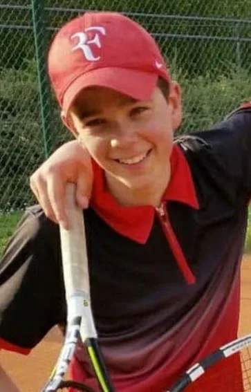 Noé, sourire aux lèvres, sa raquette à la main au bord d’un court
